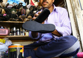 بالصور... كومار يكسب رزقه من إصلاح الأحذية والحقائب بالسنابس