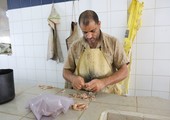بالصور... شباب بحرينيون يعملون في تقطيع وتنظيف الأسماك في سوق السمك بالسوق المركزي في العاصمة المنامة