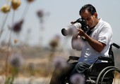 بالصور... الصحافي الفلسطيني أسامة سلوادي يواصل التصوير بعد تعرضه لشلل نصفي في ساقيه